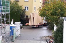 Die ersten Wandelemente rollen auf die Baustelle